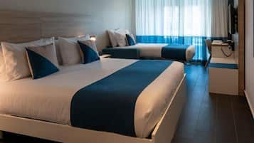Habitación de hotel con dos camas, un escritorio, una silla y un televisor.
