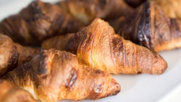 Een close-up van verschillende goudbruine croissants op een wit bord.