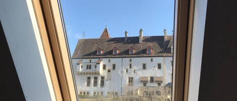 Un tragaluz con vistas a un edificio de varios pisos de estilo arquitectónico tradicional.