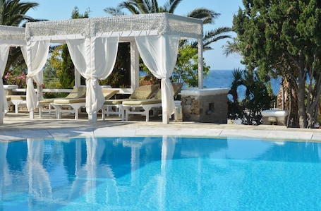 Outdoor pool, pool umbrellas, pool loungers. Zephyros Hotel