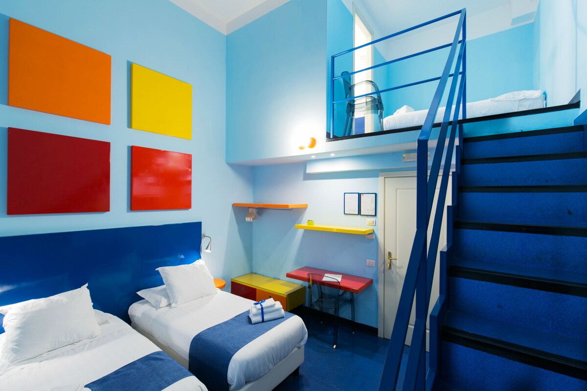 A room with bunk beds, a desk, and colorful wall art.