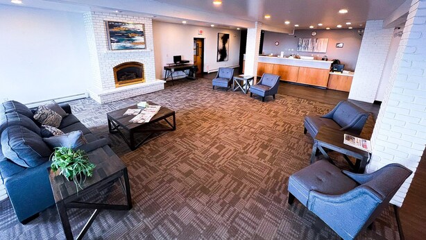 A spacious living area with a fireplace, seating, and a kitchen area.