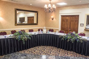 A conference room with a long table, chairs, and a chandelier. - Quality Inn & Suites Erie near Casino (Erie)