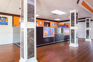 A reception area with a marble column, a reception desk, and a '6' sign.
