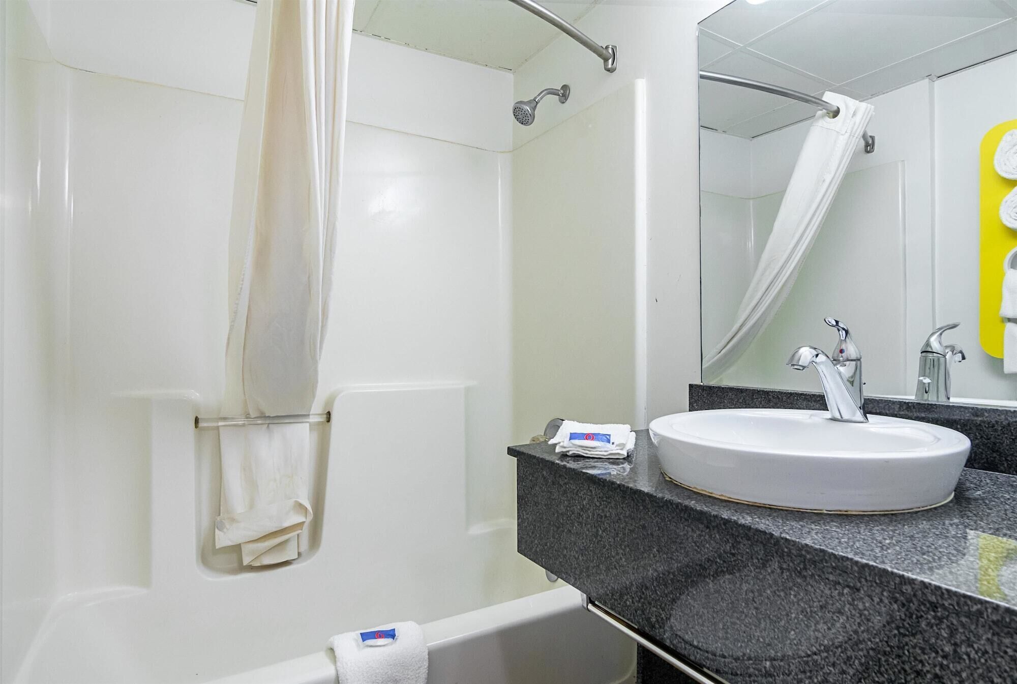 Bañera con ducha, toallas, jabón, shampoo