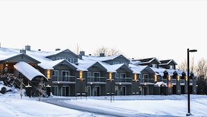 A hotel with multiple buildings, each featuring balconies and a snow-covered landscape. - Hotel Bromont (Bromont)