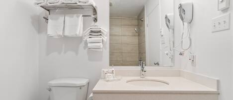 A modern bathroom with a toilet, sink, and shower area.