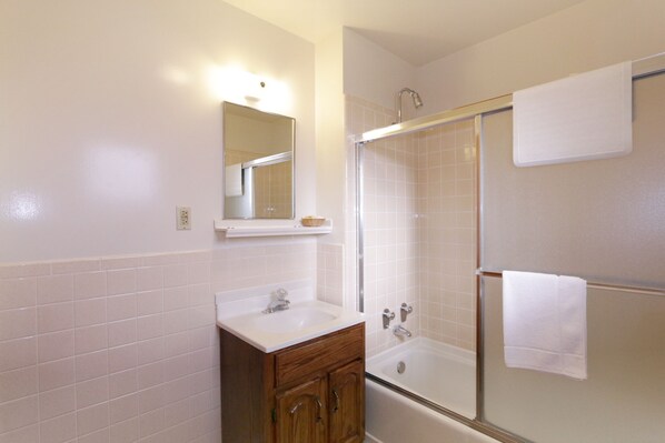 Un baño con lavamanos, espejo y ducha.