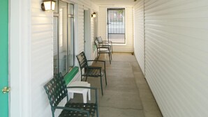 A corridor with benches and a door, leading to a room with a window. - Town House Motel (Winnemucca)