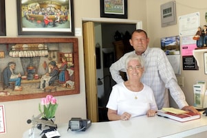 Un área de recepción con mostrador, cuadros en la pared y un reloj.