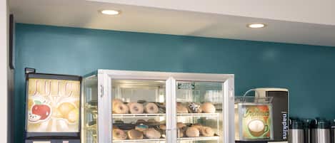 Une enseigne Krispy Kreme, un présentoir à beignets et un réfrigérateur pour les jus.