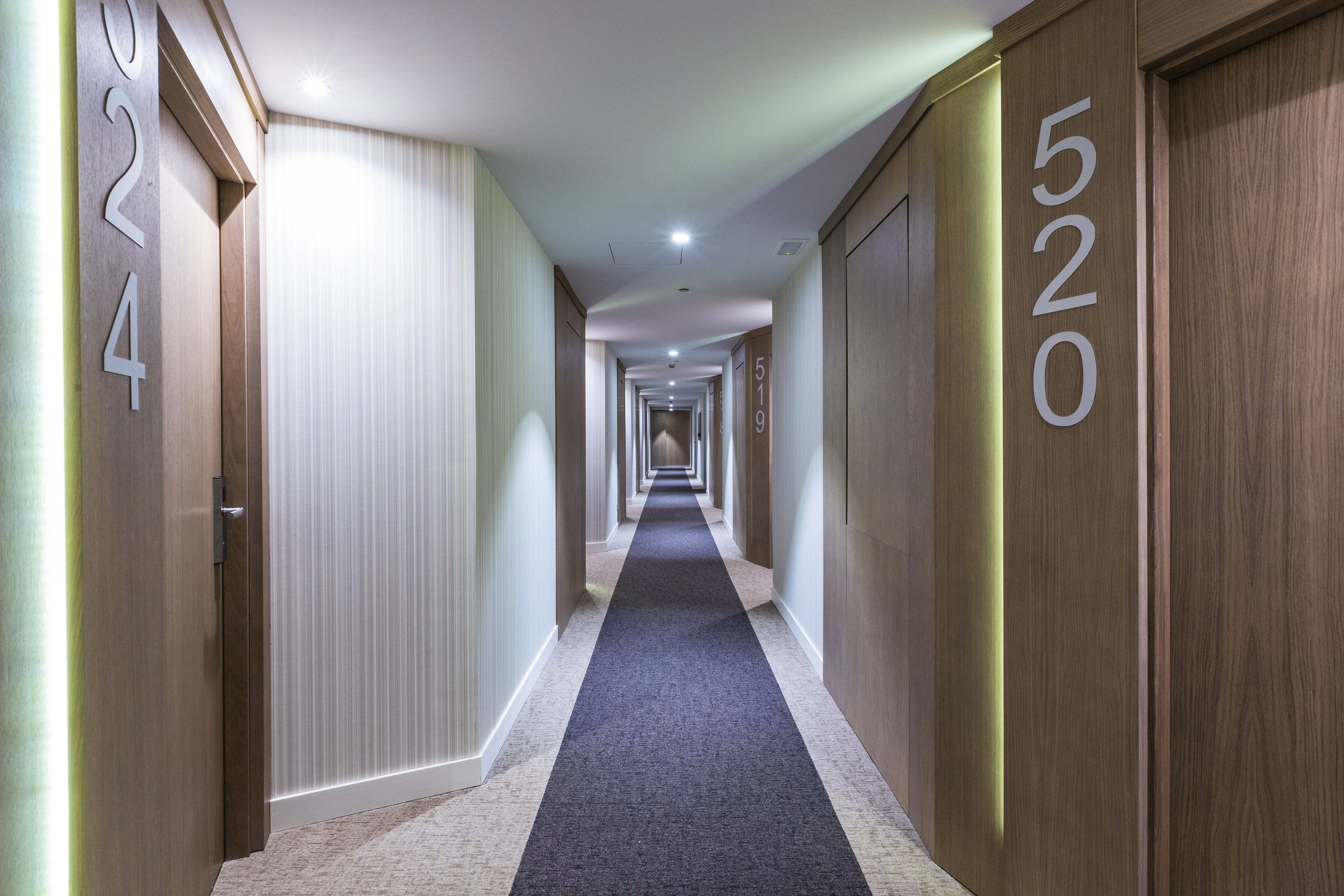 Pasillo de hotel con puertas numeradas 202, 519 y 520.