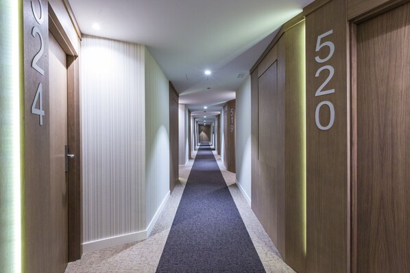 Corridoio di un hotel con le porte contrassegnate con i numeri 202, 519 e 520.