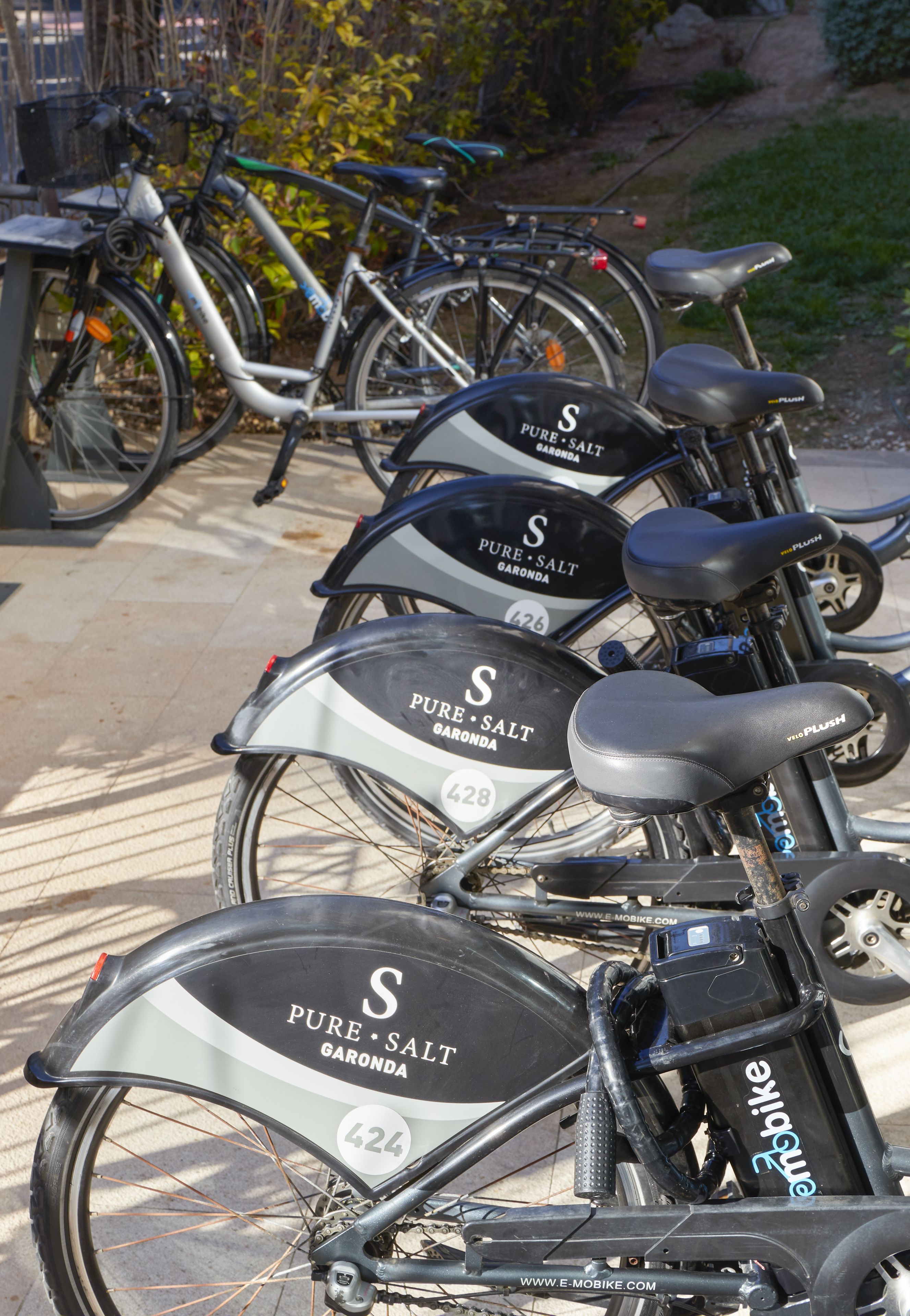 Una fila de bicicletas con el rótulo 'PURE SALT GARONDA', estacionadas sobre una superficie pavimentada.