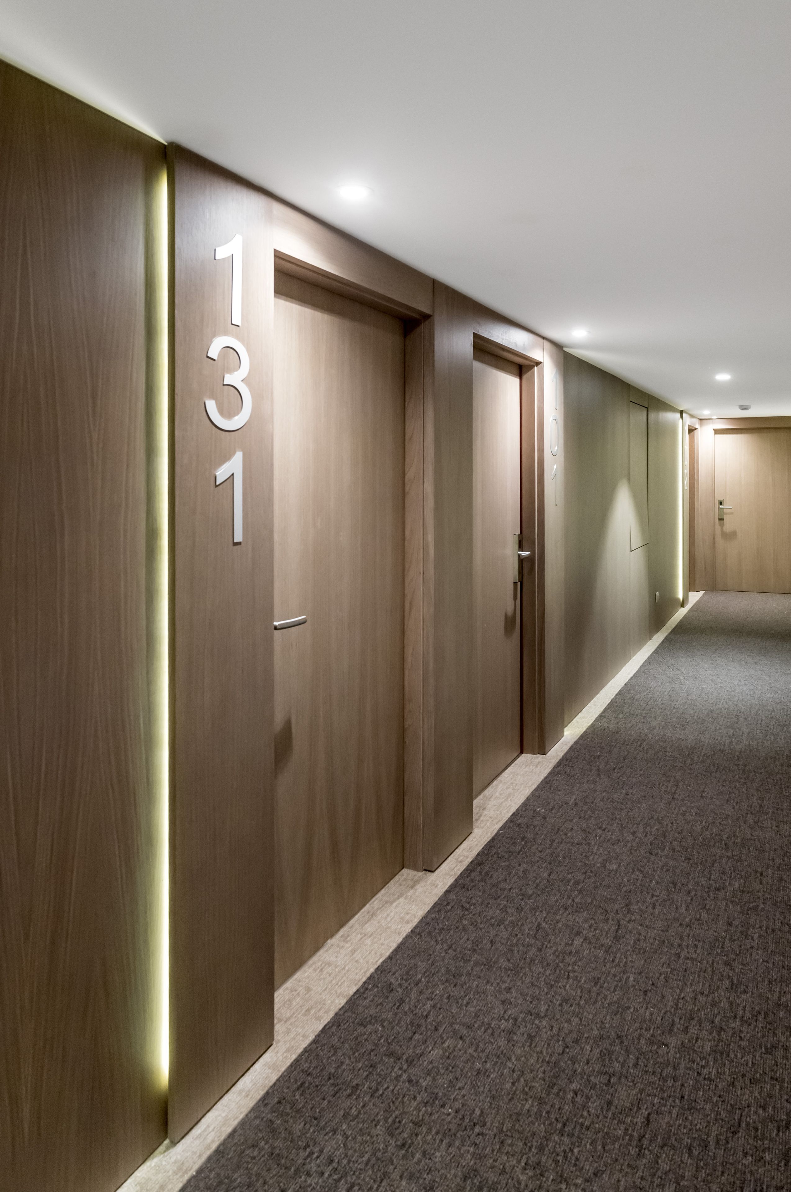 A hallway with wooden doors, each marked with a number.