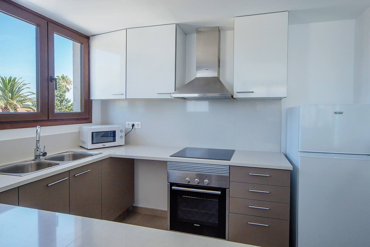 A modern kitchen with a microwave, oven, and refrigerator.