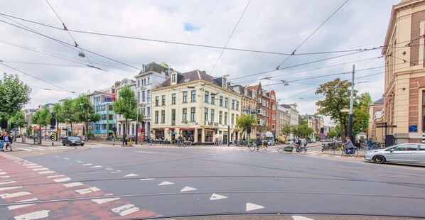 Une rue avec des voies de tramway, des immeubles et un tramway en mouvement.