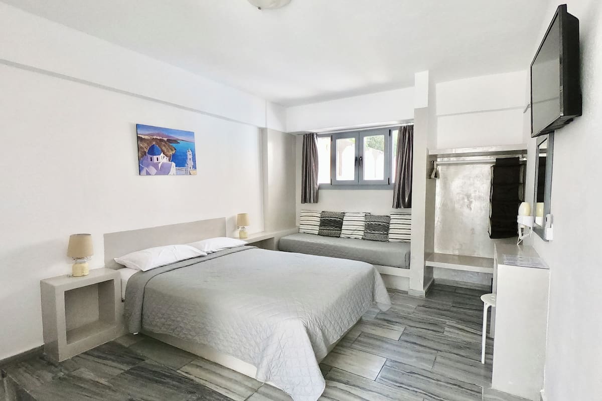 Deluxe driepersoonskamer, 1 tweepersoonsbed met slaapbank, uitzicht op zwembad | 1 slaapkamer, een kluis op de kamer, een bureau, een laptopwerkplek