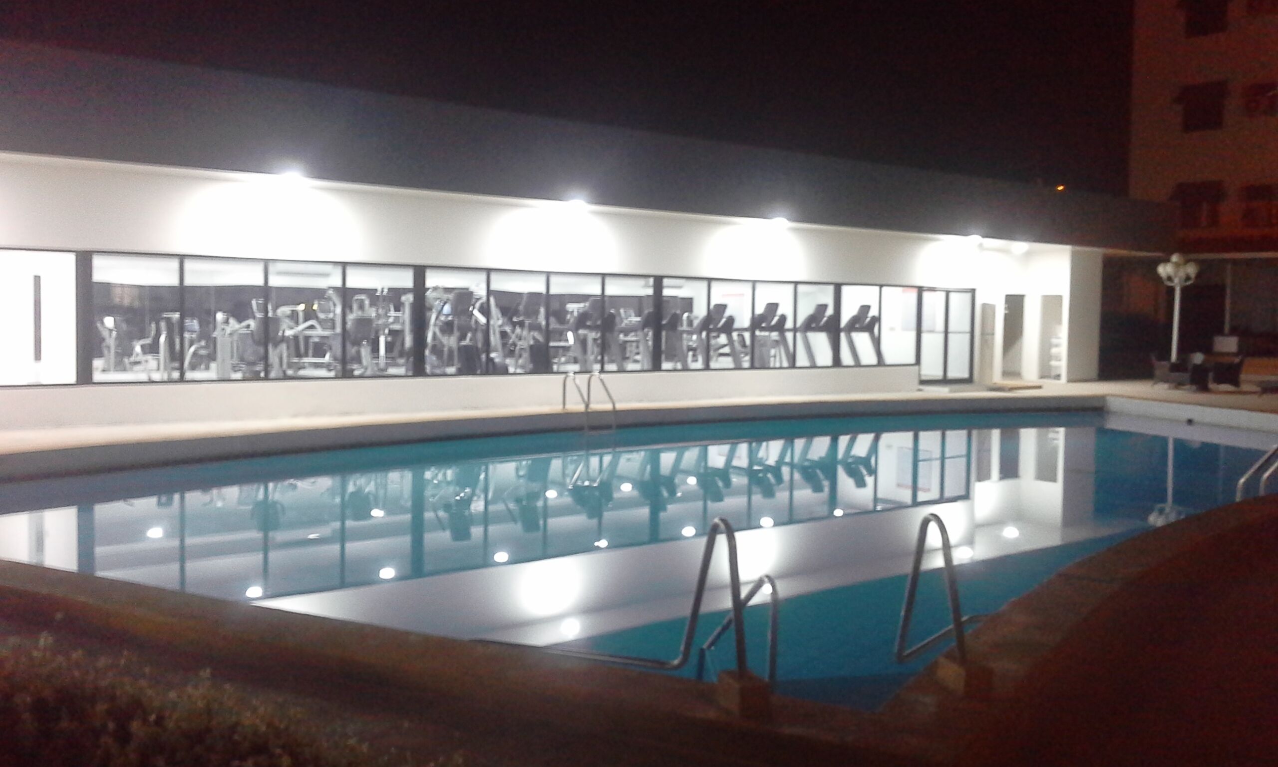 A swimming pool with a modern building in the background.