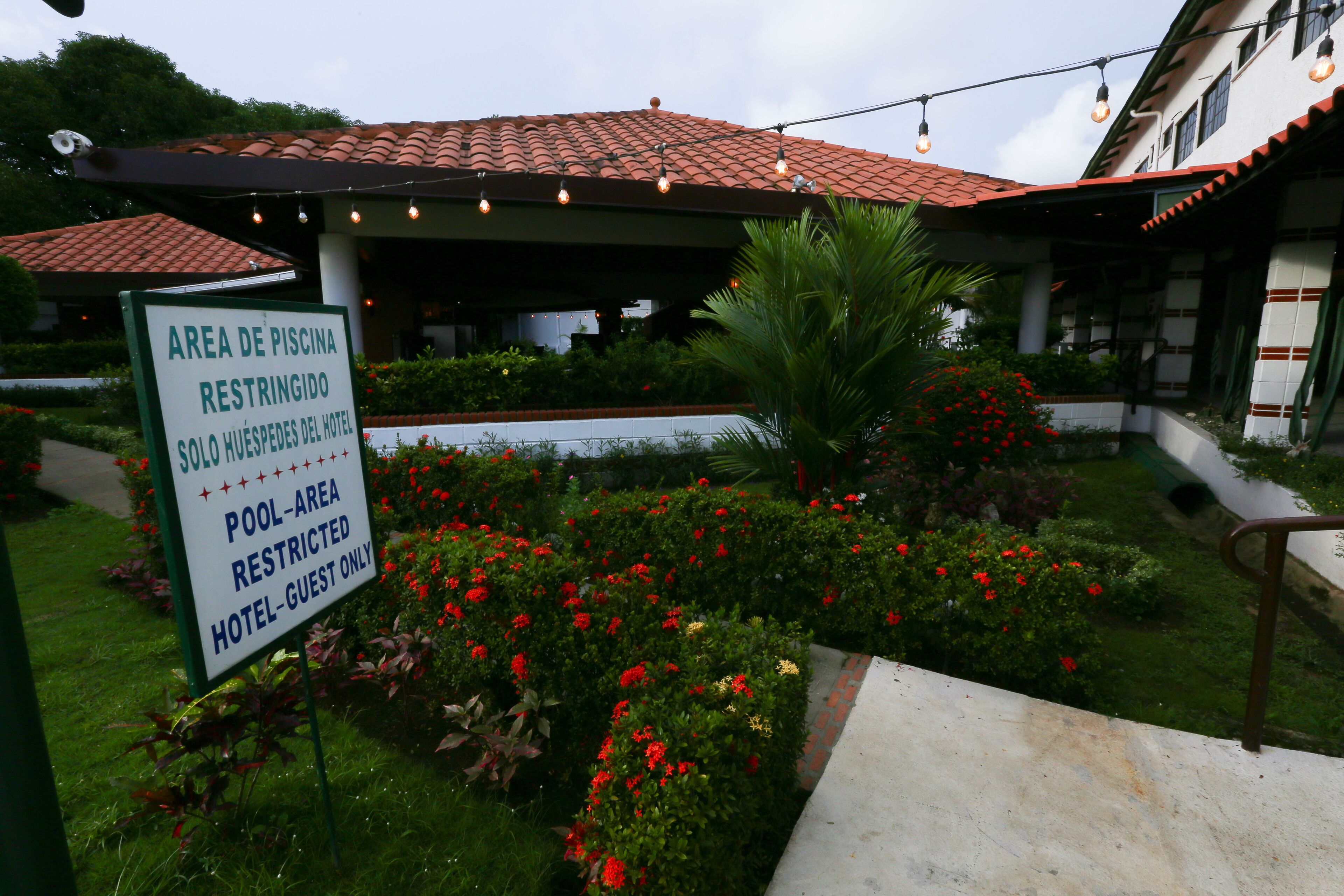 Entrada de hotel con letrero que indica área de piscina restringida para huéspedes.