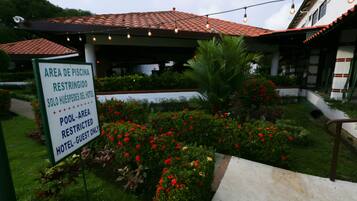 Entrada de hotel com placa indicando área da piscina restrita a hóspedes.