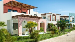Un complejo residencial moderno con varias edificaciones, cada una con estilos arquitectónicos diferentes, techos planos y ventanas de arco.