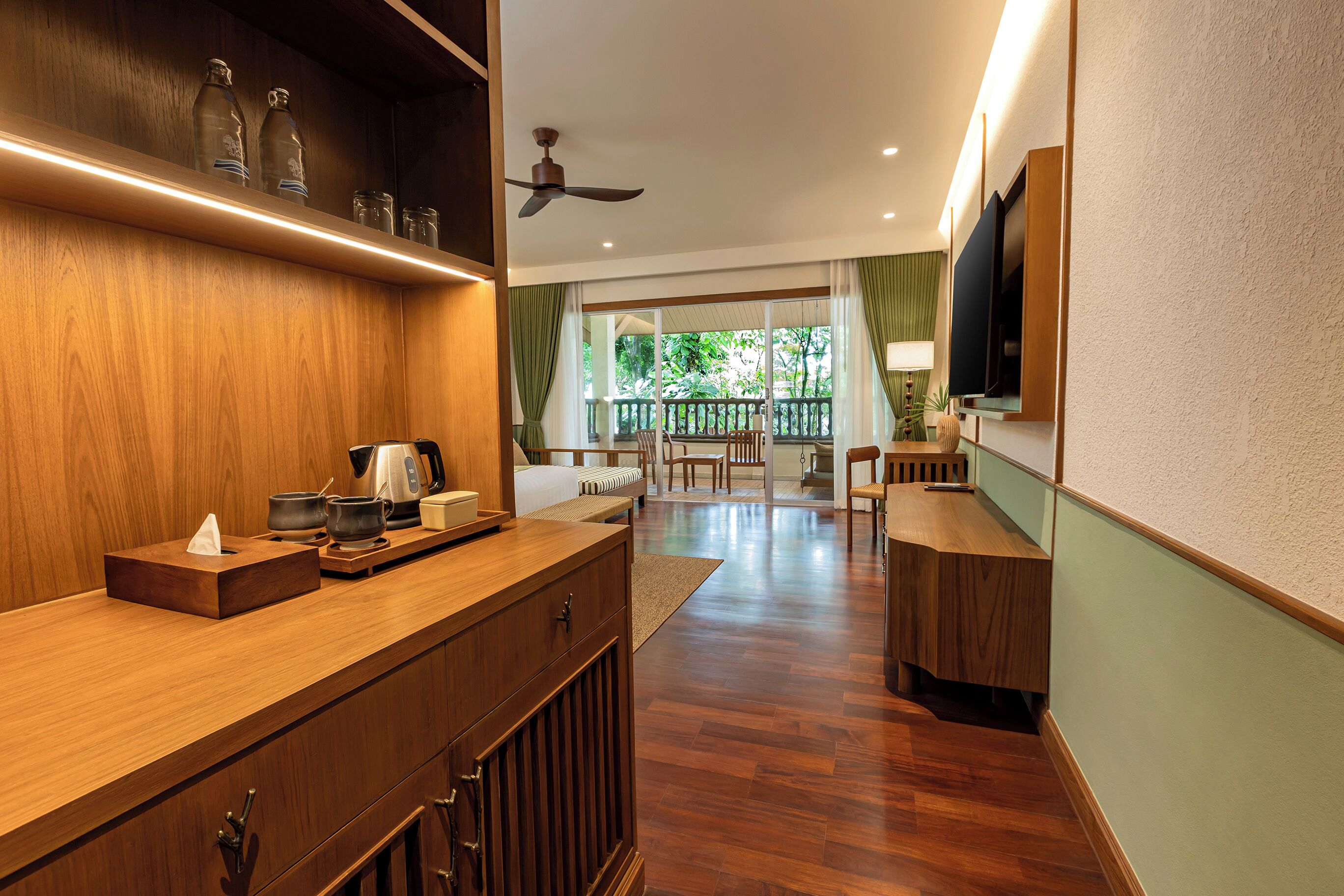 Een moderne keuken met houten kastjes, een aanrecht en een plafondventilator.