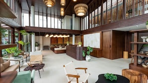 A spacious lobby with wooden accents, a reception desk, and seating areas. - Pakasai Resort (Krabi)