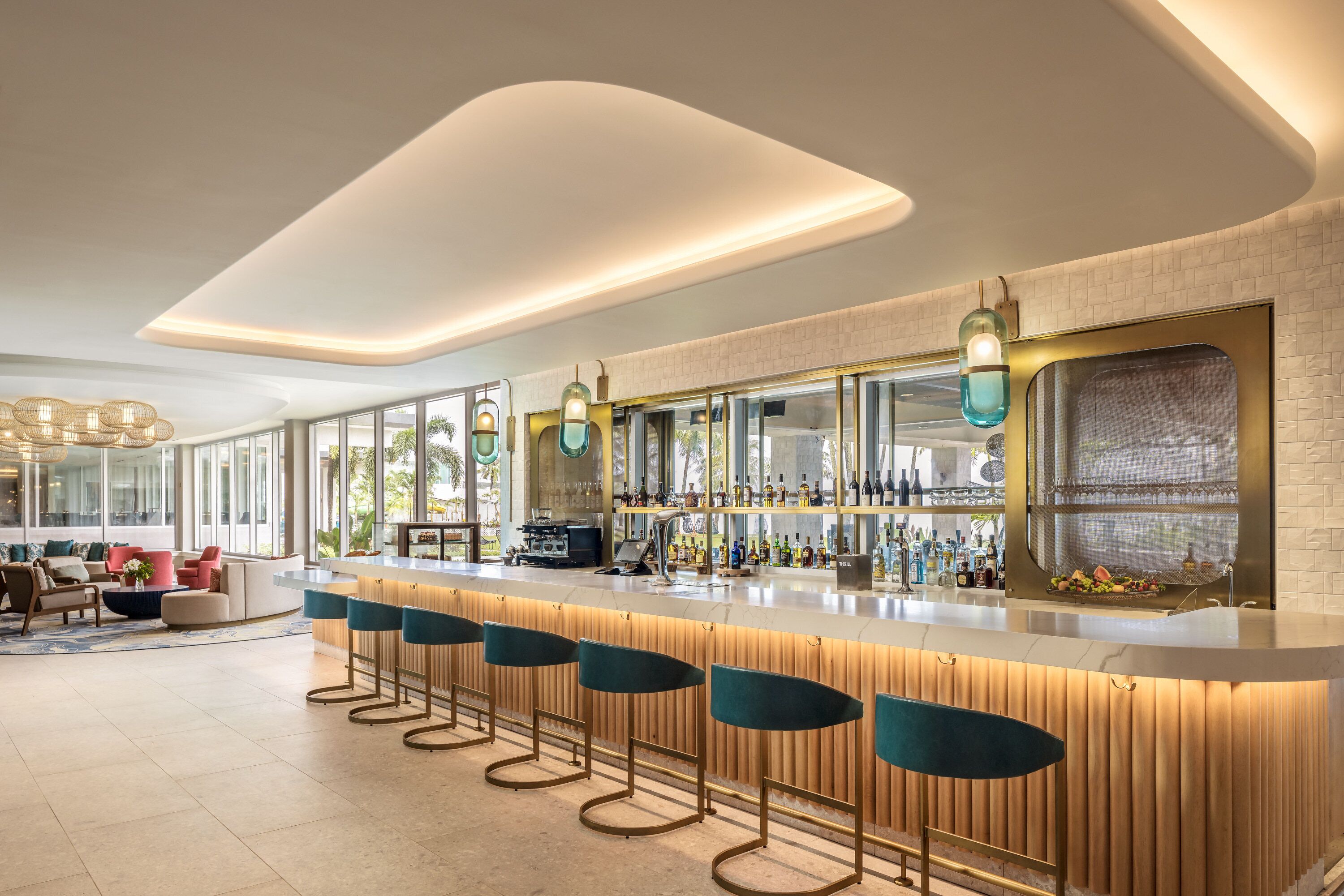 Un área de bar moderna con una barra larga, taburetes y una variedad de botellas.