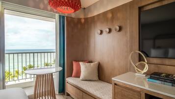 Una habitación moderna con un banco de madera, una mesa redonda y una lámpara colgante roja.