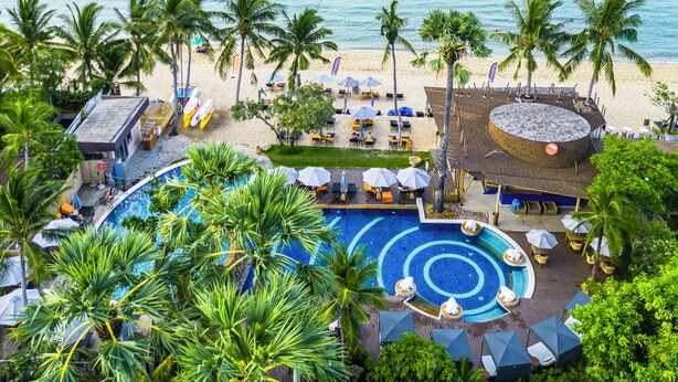 Un resort con piscina, playa y vista al océano.