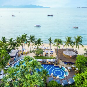 Un resort con piscina, playa y vista al océano.