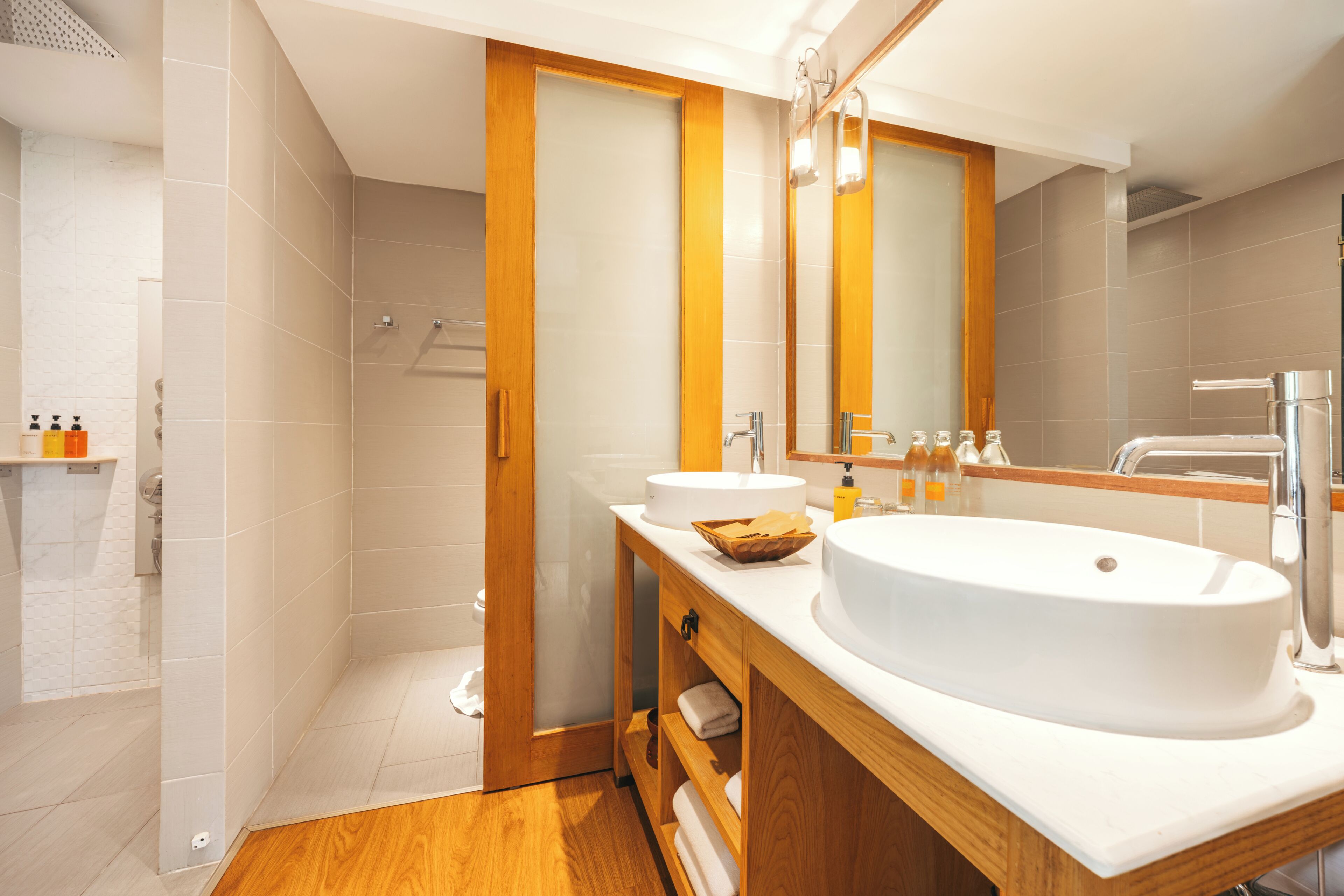 Un baño moderno con un lavamanos grande, espejo y ducha.