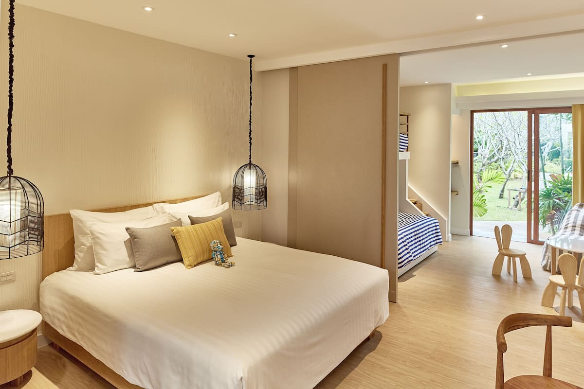 Una habitación de hotel moderna con una cama grande, un comedor y vistas al exterior.