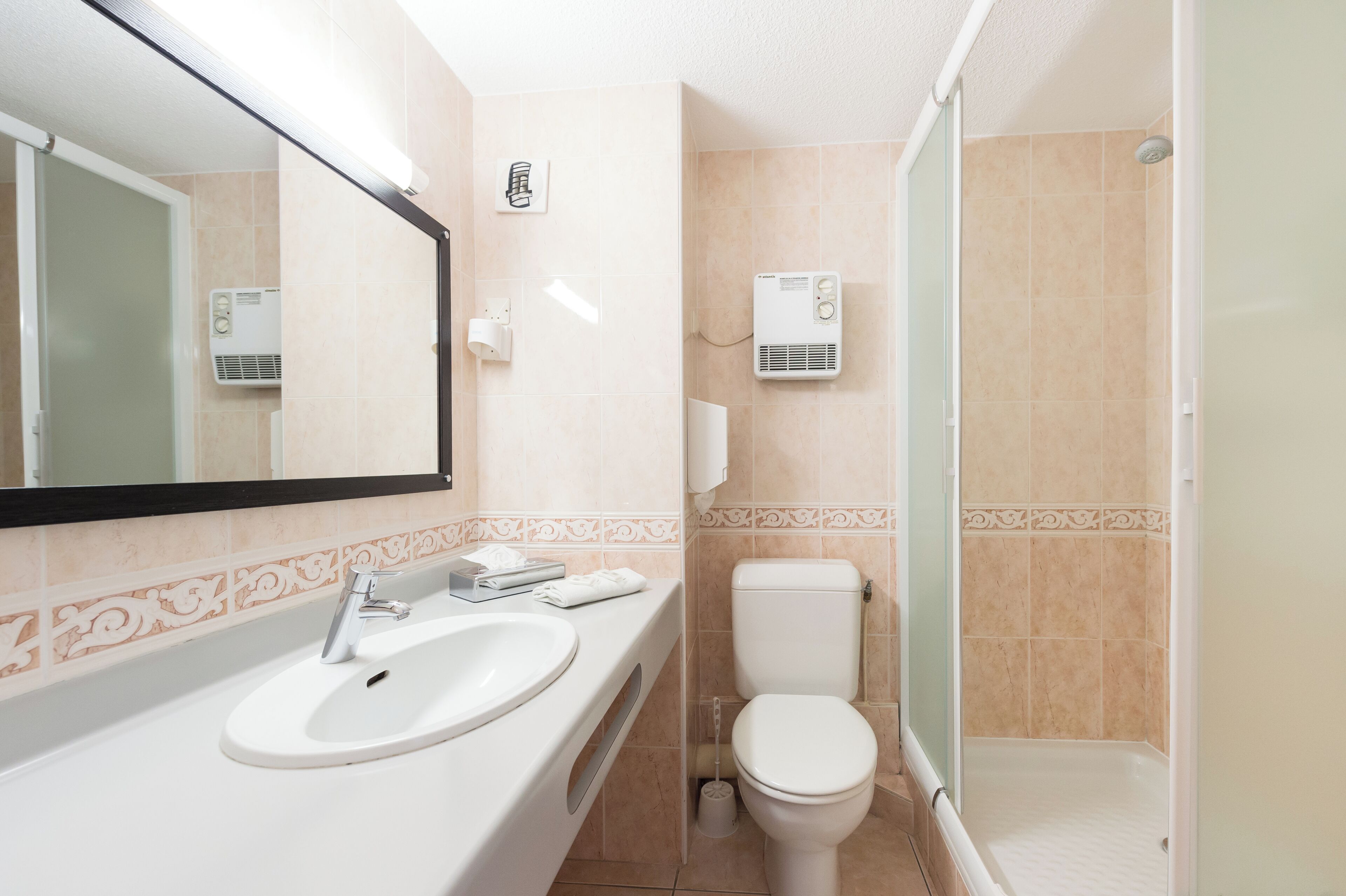 A bathroom with a sink, toilet, and shower.