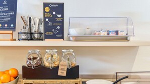 Montaje de desayuno tipo buffet con diversos alimentos y utensilios.