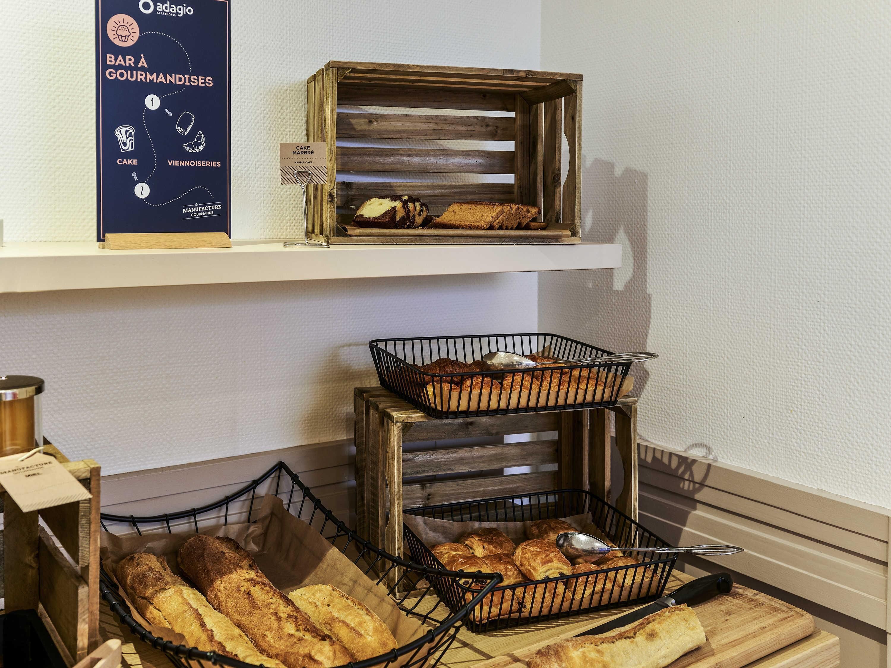 A bakery display with various baked goods on shelves and in baskets.