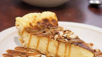A dessert on a plate with caramel sauce and almonds.