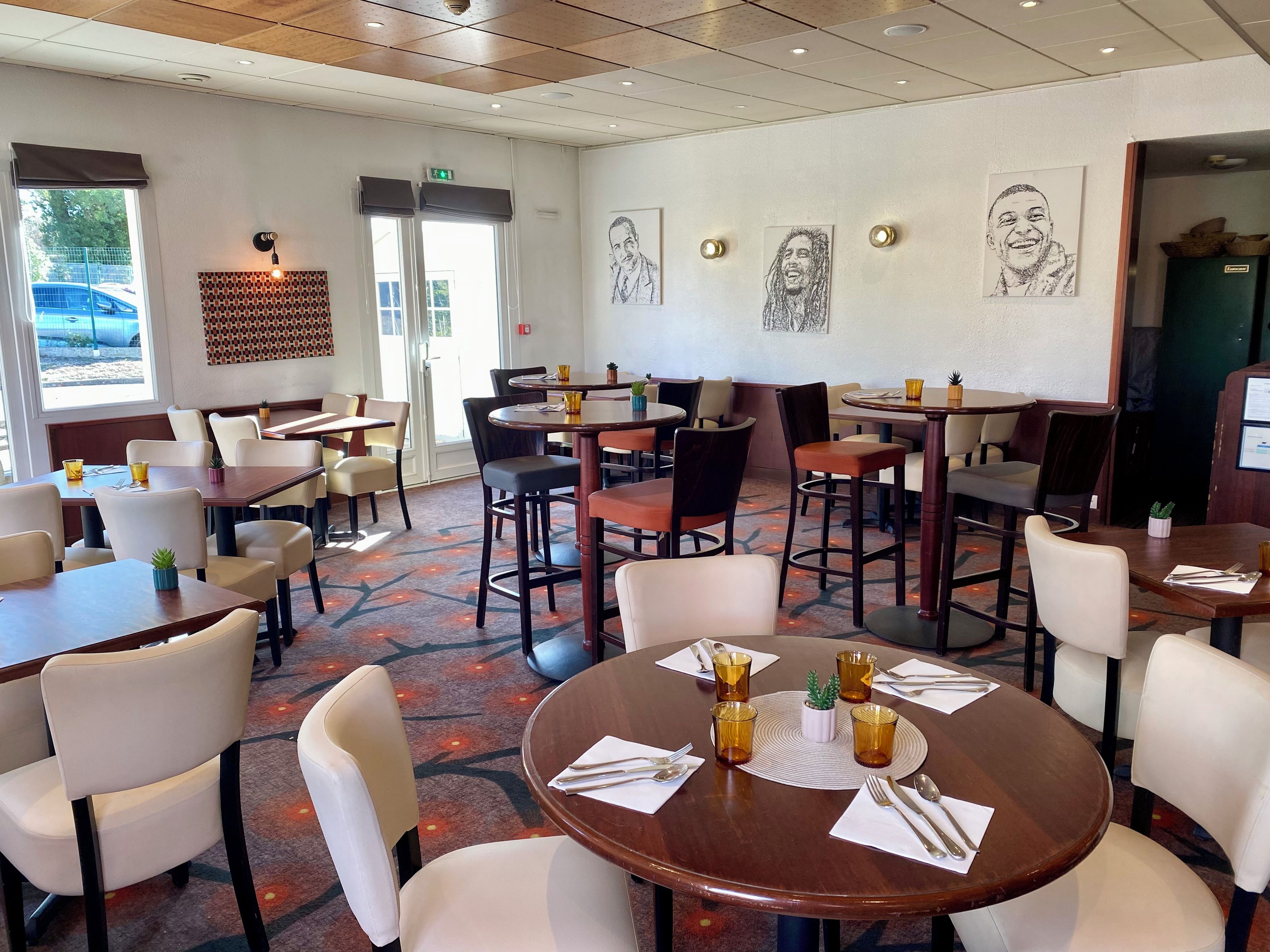 Un restaurante con varias mesas y sillas, algunas con vasos y servilletas amarillas.