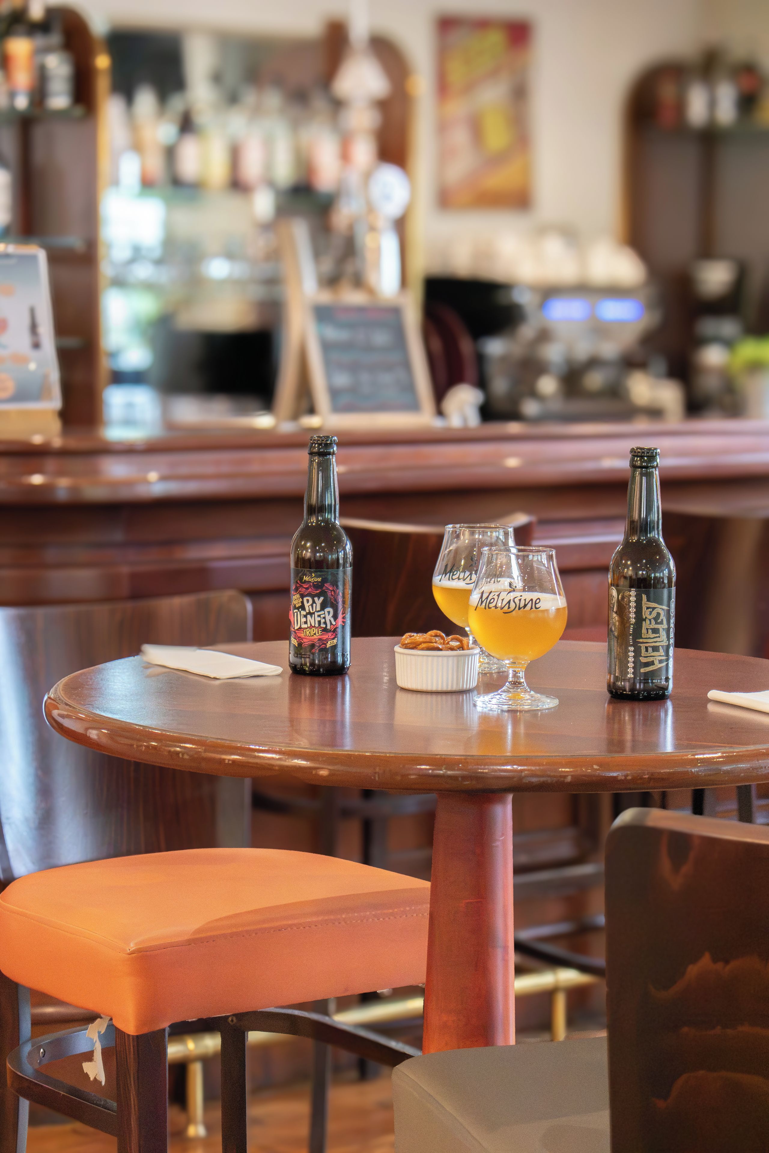 Een bar met twee flessen en twee glazen op een houten tafel.