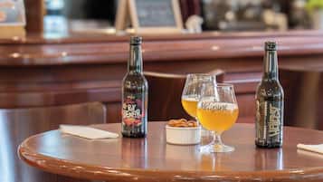 A bar setting with two bottles and two glasses on a wooden table.