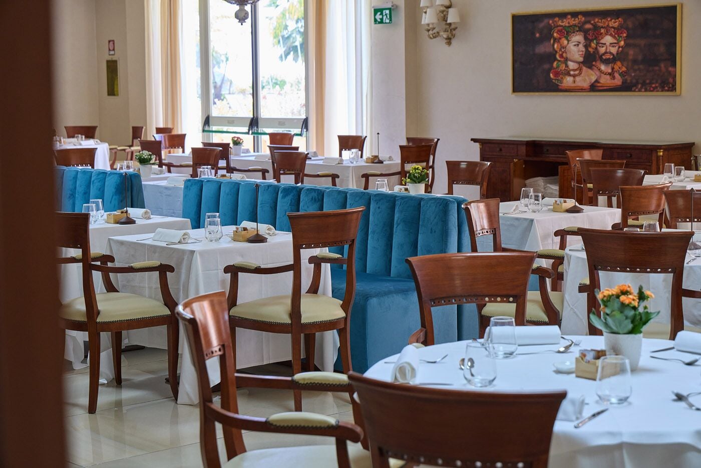 Un restaurant avec plusieurs tables, des chaises et une grande fenêtre.