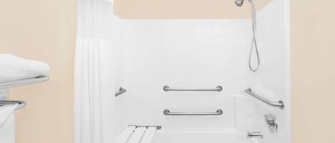 A modern bathroom with a walk-in shower, grab bars, and a white bathtub.
