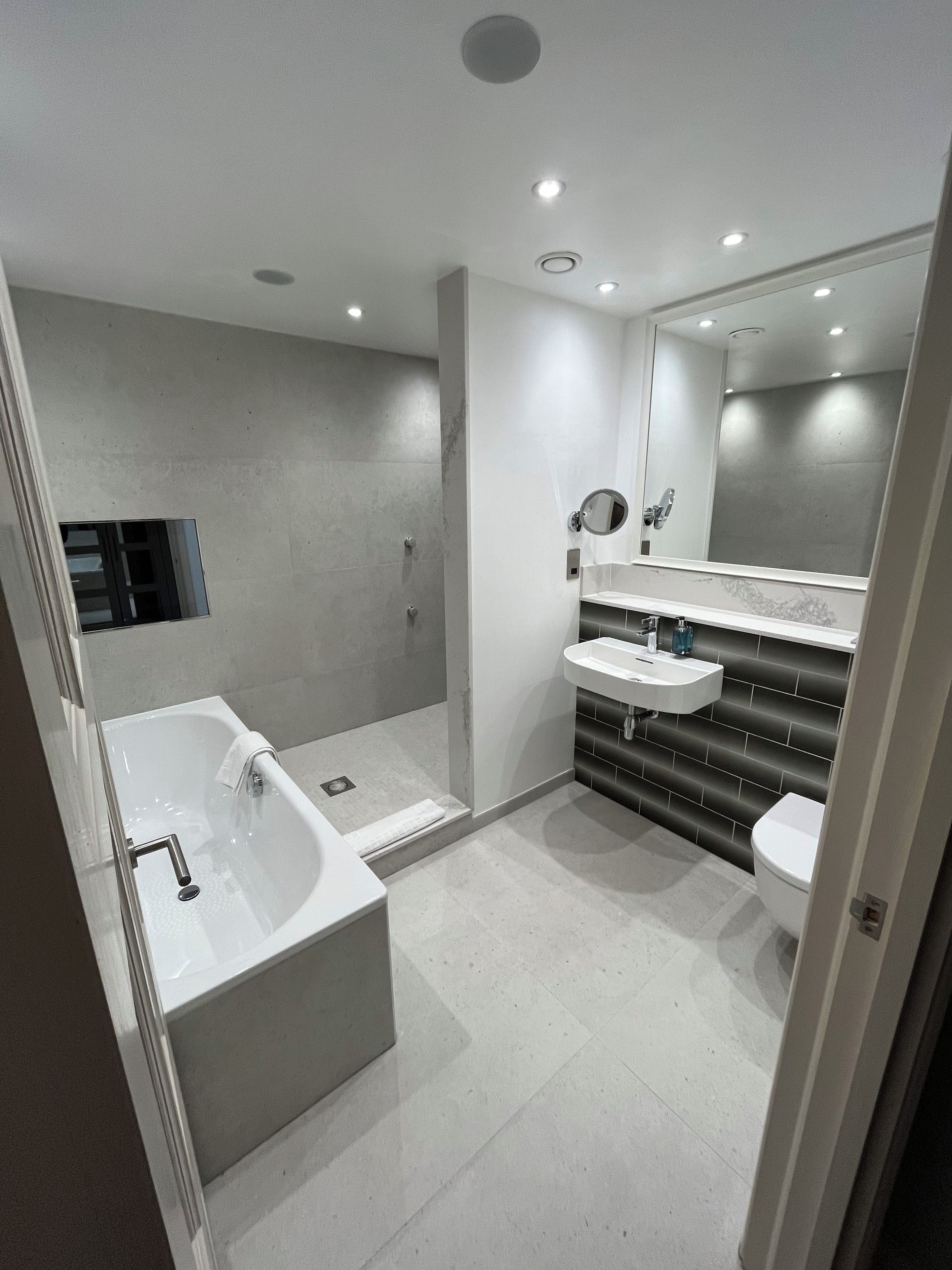Ein modernes Badezimmer mit Badewanne, Dusche und Toilette.