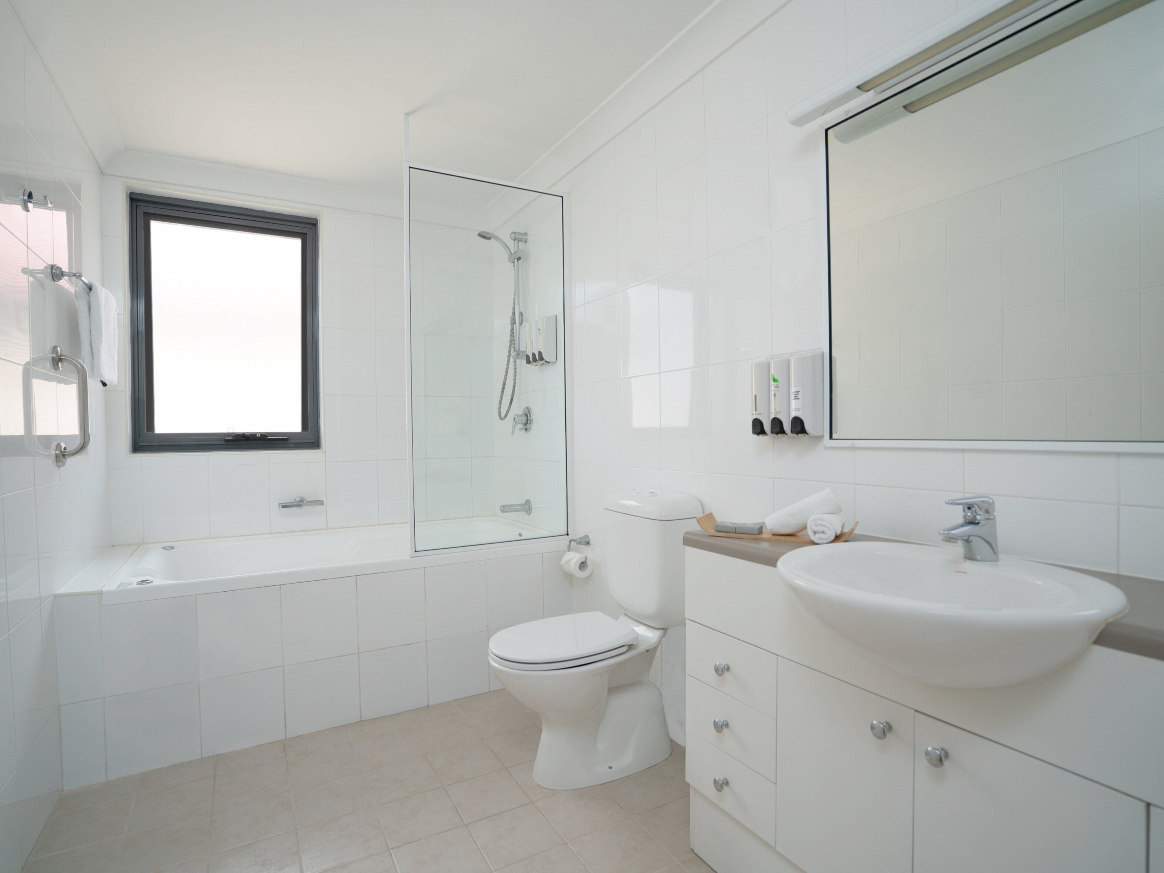 A modern bathroom with a bathtub, toilet, and sink.