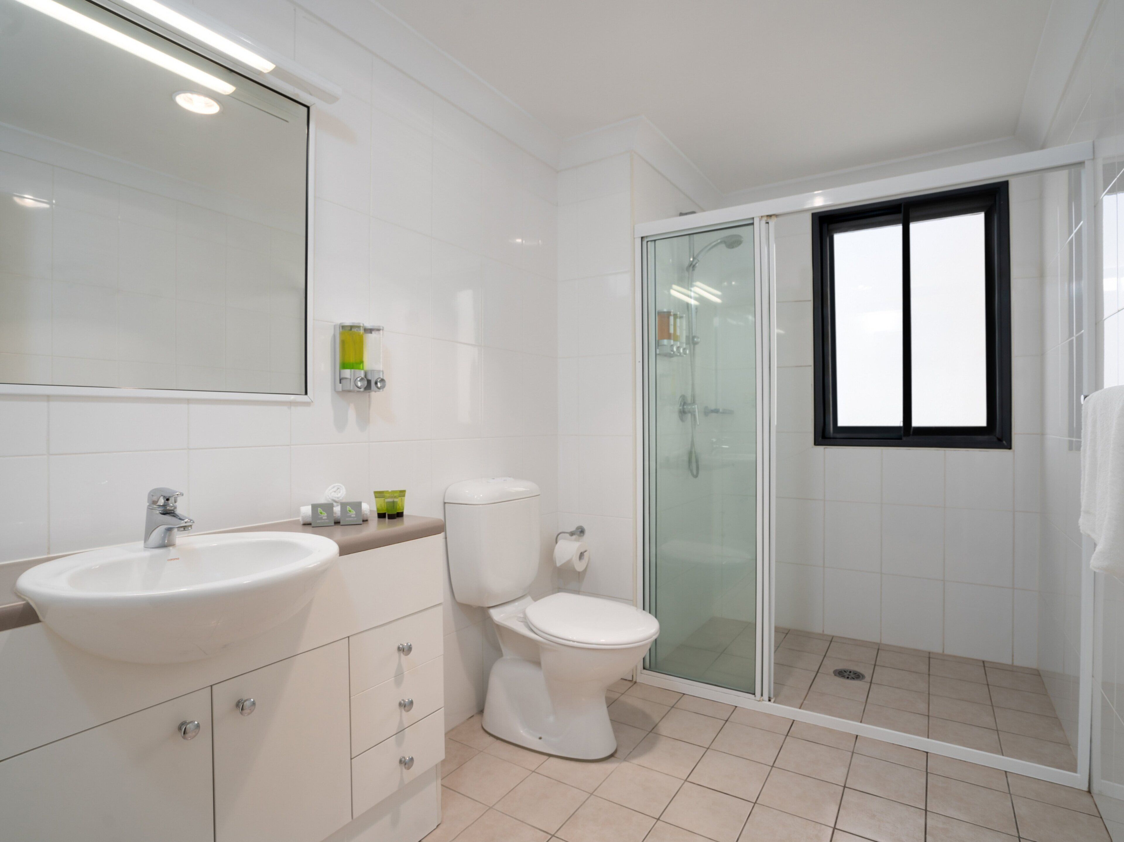 A modern bathroom with a sink, toilet, and glass-enclosed shower.