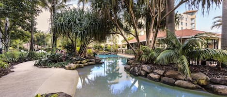 A pool area with tropical plants and a clear water surface.