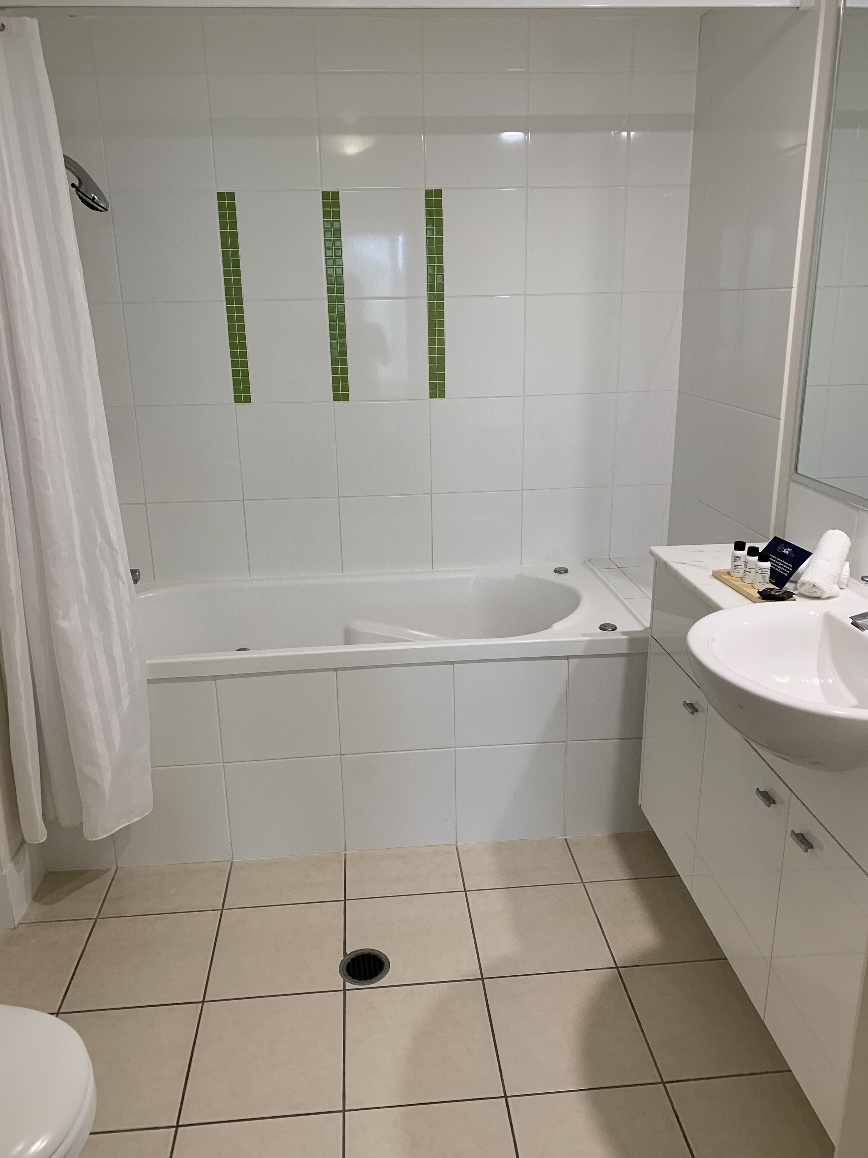 Et badeværelse med badekar, vask og toilet.