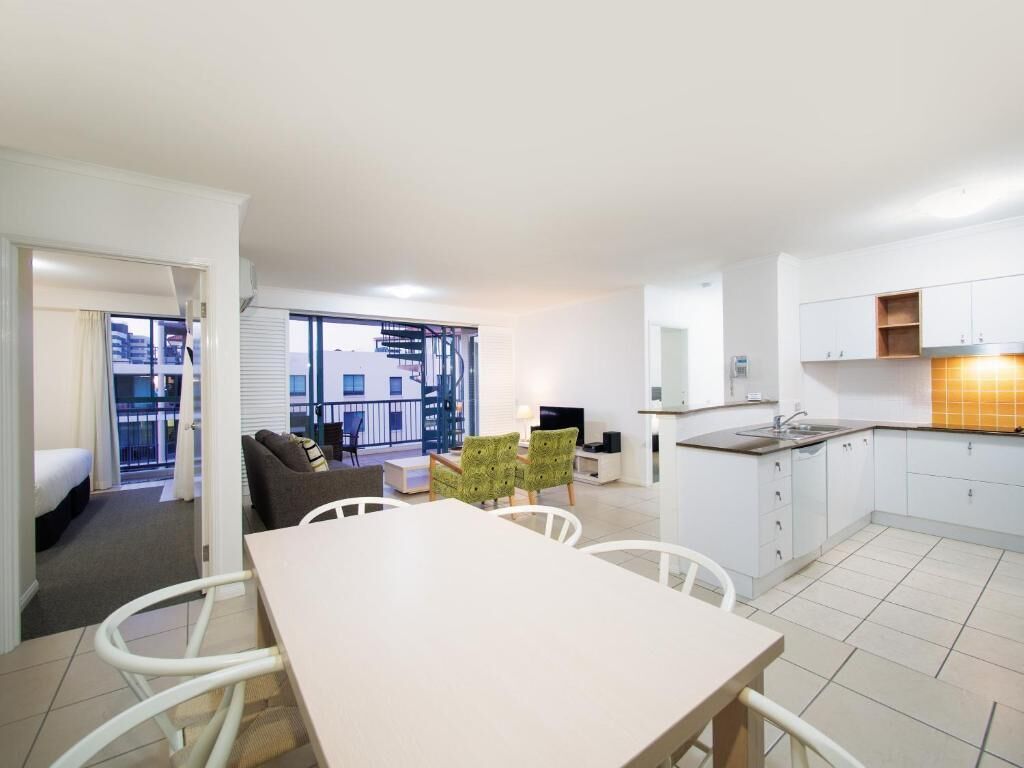 A modern apartment with a dining area, kitchen, and a balcony with a view.