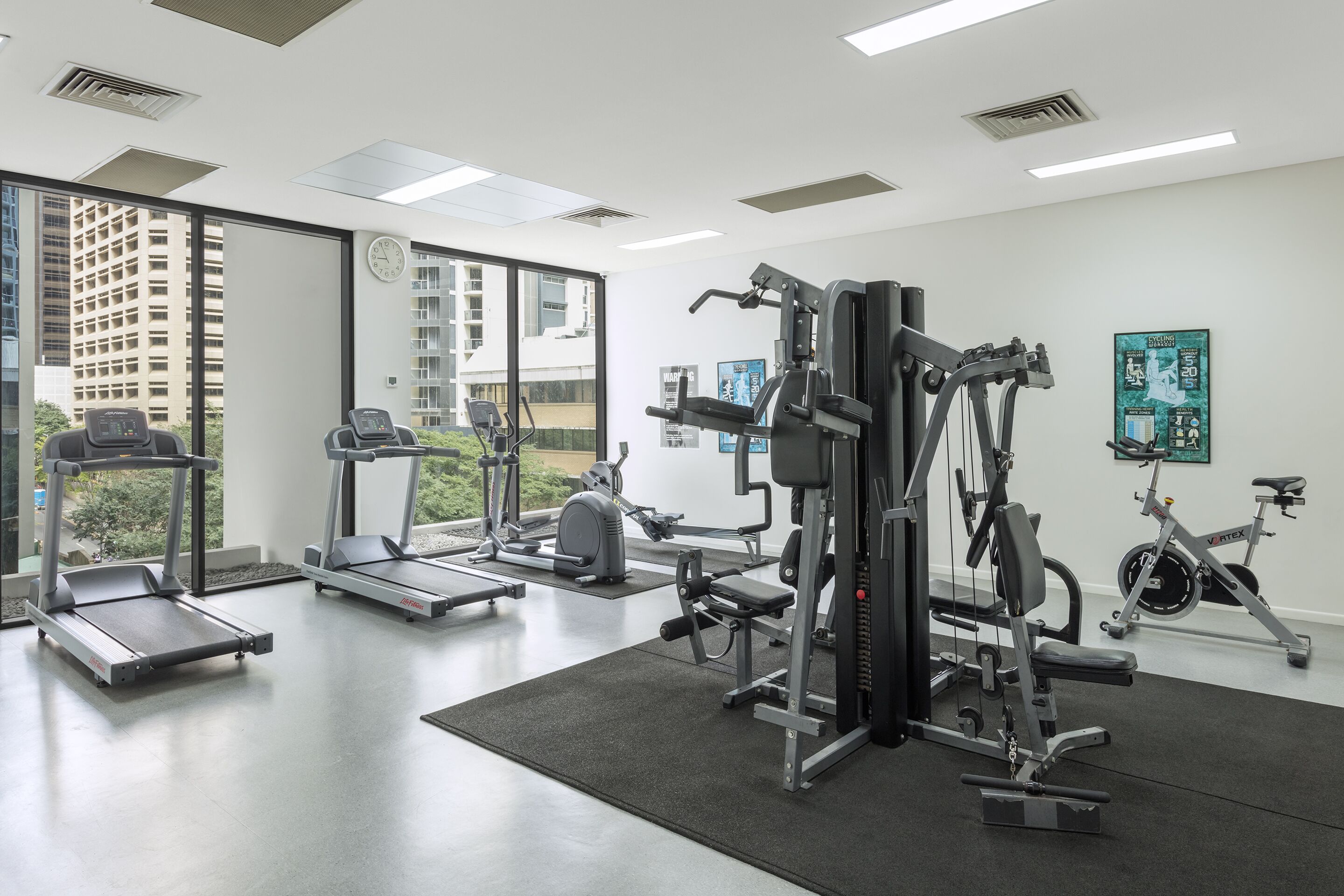 A gym with treadmills, a weight machine, and a stationary bike.
